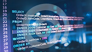 SQL (Structured Query Language) code on computer monitor and server room background