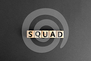 Squad - word from wooden blocks with letters