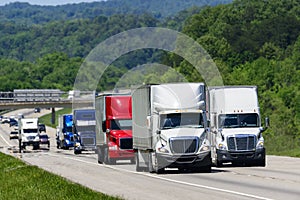 A squadron of eighteen-wheelers lead the way down an interstate highway in eastern Tennessee