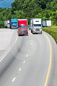 Squadron of Heavy Trucks On Interstate With Copy Space