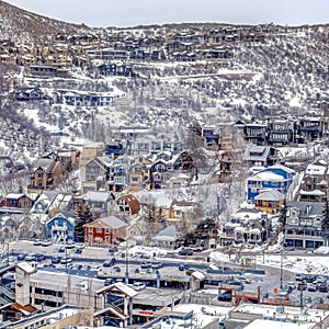 Square Aerial view of houses and buildings in the residential area of a snowy mountain