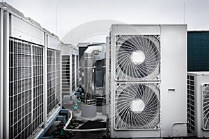 Square air conditioning units on roof with round fan grills