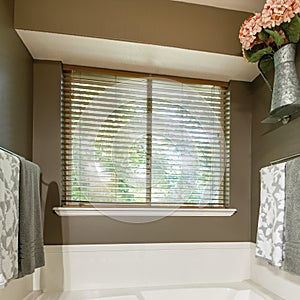 Square Alcove bathtub with deck mounted faucet near the window