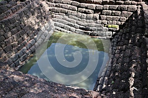 Square ancient pond, made from laterite stone in archaeological site of Srithep ancient town in Petchaboon.