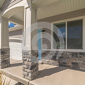 Square Arched entrance at the porch of home with blue front door beside window