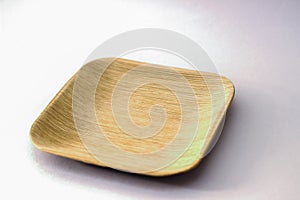 Square Areca Leaf Plate, eco-friendly disposable cutlery. Side view on a white background