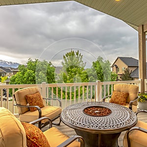 Square Balcony with chairs around table with fire pit against homes and mountain view