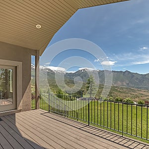 Square Balcony of a home with metal ailing and stairs that leads to the lush green lawn