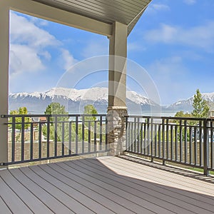 Square Balcony overlooking homes lake and mountain under blue sky on a sunny day