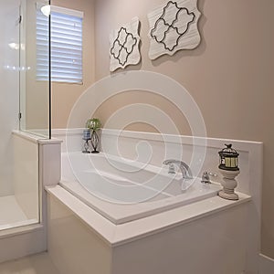 Square Bathroom interior with a polished built in bathtub and shower stall