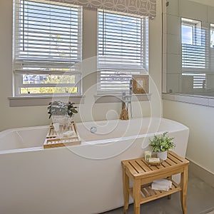 Square Bathtub and shower stall in front of windows with valance and blinds