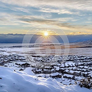 Square Beautiful sunrise in Draper Utah with snowy hills lake and houses in winter