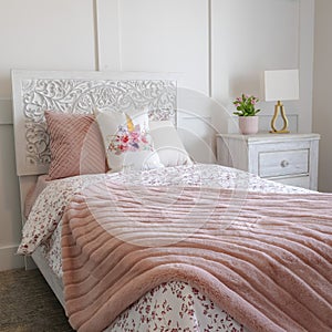 Square Bedroom interior with decorative headboard and feminine beddings on single bed photo