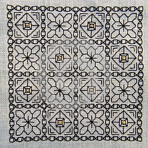 Square Blackwork embroidery with gold highlights. photo