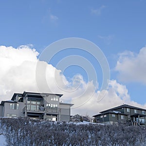 Square Blue sky and puffy clouds over homes on an inceredible mountain setting in winter