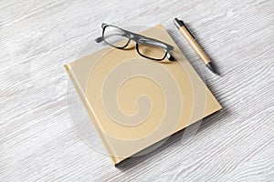 Square book, glasses, pen