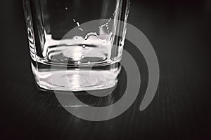 Square Bottom of Empty Beer Glass on Dark Table Surface. Bubbles Left from the Beer Head or Collar, Frothy Foam on Top of the