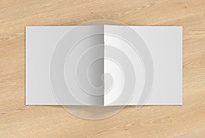 Square brochure or booklet cover mock up on wooden background. Brochure is open and upside down. Isolated with clipping path aroun