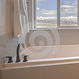 Square Built in square bathtub inside a bathroom with white wall and sliding window