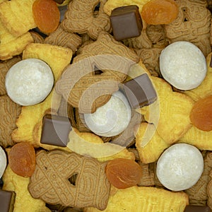 square Christmas background made of different varieties of speculaas, pepper nuts, dominoes and dried apricots