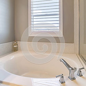 Square Clean built in round bathtub beside glass wall of shower stall of home bathroom