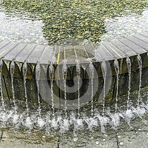 Square Clear water of circular pool fountain reflecting the Utah State Capital Building