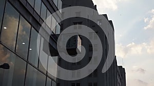 Square clock hanging from a building with beautiful sky as background