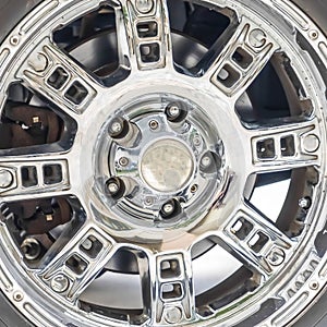 Square Close up of the black rubber tire of an off roading truck with shiny chrome mags