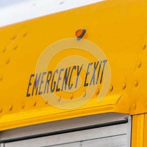 Square Close up of the exterior of a yellow school bus with an Emergency Exit sign