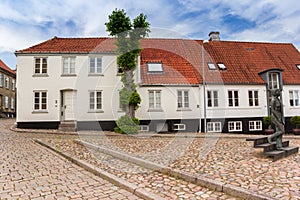 Square with cobblestones and historic houses in Haderslev