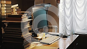 Square computer monitor on table with pile of books in old archive interior