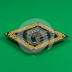Square computer processor chip with a green circuit board, surrounded by a dense
