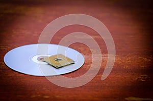 A square computer processor pulled from a broken computer. The processor is on the table. View of the contacts through a magnifyin