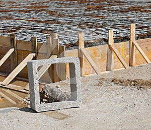 square concrete product and formwork made with yellow wooden planks during laying cement to make the foundation of the building