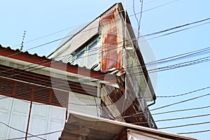 Square corner gable  The roof of the house and the windows are rusty, the old Asian style wooden house.  Sky background