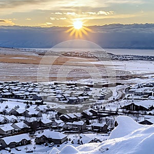 Square crop Beautiful sunrise in Draper Utah with snowy hills lake and houses in winter