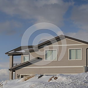 Square crop Home against cloudy blue sky at the snowy neighborhood of Wasatch Mountain