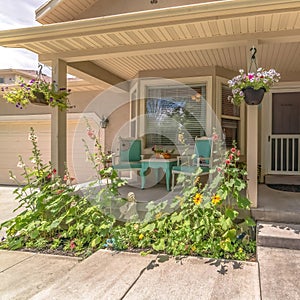 Square crop Home exterior with bay window on front porch decorated with flowers and plants