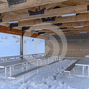Square crop Pavilion with wooden ceiling and beams at the snowy Wasatch Mountain terrain