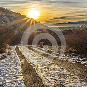 Square crop Snowy dirt road in Provo Canyon overlooking lake mountain and sun at sunset
