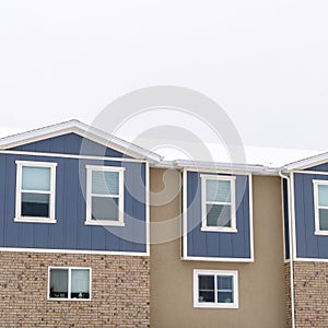 Square crop Townhome exterior with sliding glass windows brick walls and vertical sidings