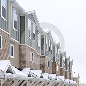 Square crop Townhome facade with snowy gabled roof at the entrance in winter photo