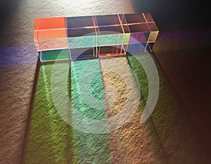 Square dichroic glass cubes spreading beam of light into many color spectrums.