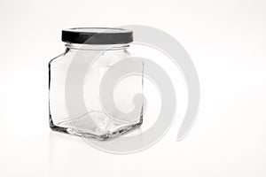 Square empty glass jar with black lids.