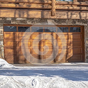 Square Facade of a luxury wooden home in Park City Utah with snowy driveway in winter