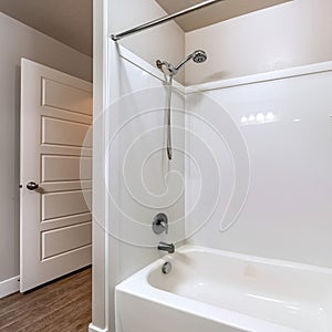 Square frame BAthroom interior with built in bathtub stainless steel shower head and faucet