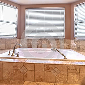 Square frame Bathroom interior with close up of bay windows and elevated built in bathtub