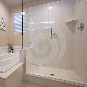 Square frame Bathroom interior with a polished built in bathtub and shower stall