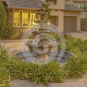 Square frame Beautiful tiered fountain at the garden of a home against sky with gray clouds