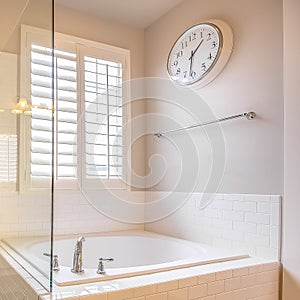 Square frame Built in bathtub and shower stall with glass door inside a bathroom